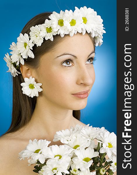 Young, beautiful and naked woman with bouquet of white flowers. Blue background. Young, beautiful and naked woman with bouquet of white flowers. Blue background