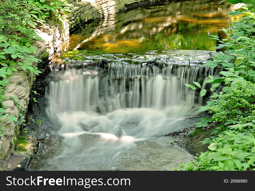 Beautiful garden stream with small waterfall.