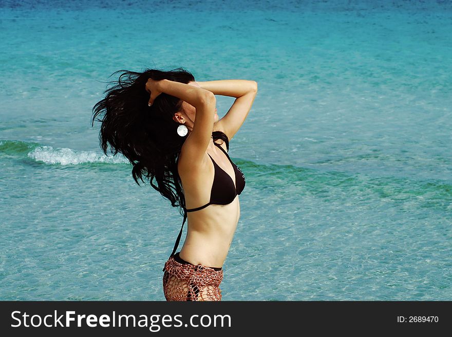 Bikini girl doing hairdance with ocean waves background. Bikini girl doing hairdance with ocean waves background