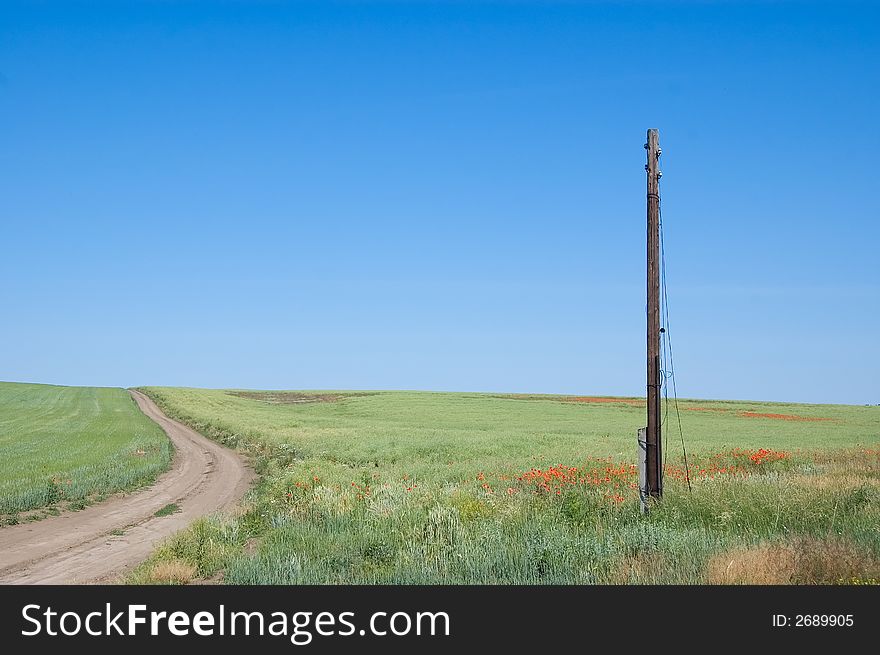 Rural landscape with green meadow, old telegraph pole and blue sky. Rural landscape with green meadow, old telegraph pole and blue sky