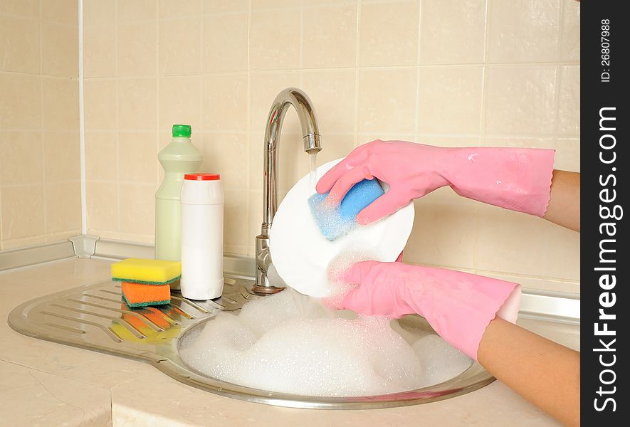 Women's hands washing dish in the kitchen. Women's hands washing dish in the kitchen