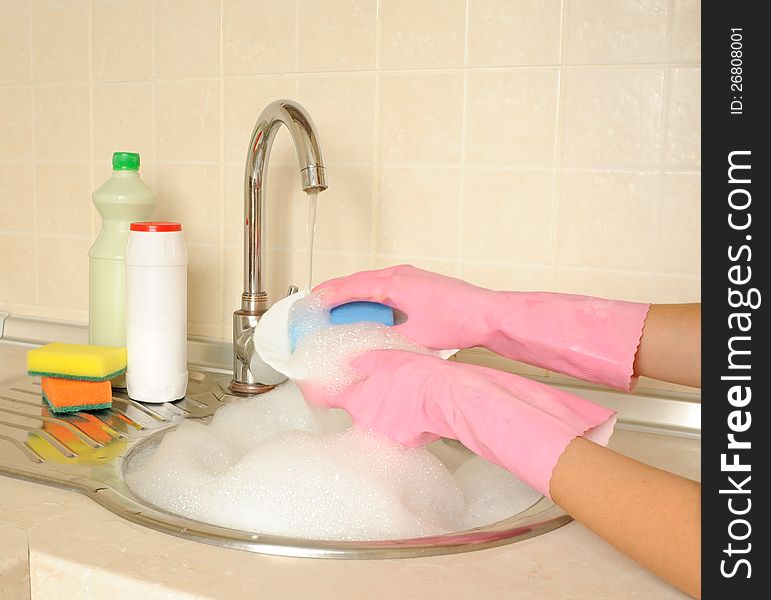 Women's hands washing dish in the kitchen. Women's hands washing dish in the kitchen