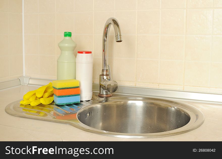 Detergent bottles and sponges near the faucet in the kitchen