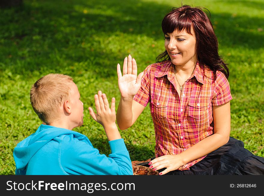 Mother and son play outside on field in the park. Mother and son play outside on field in the park