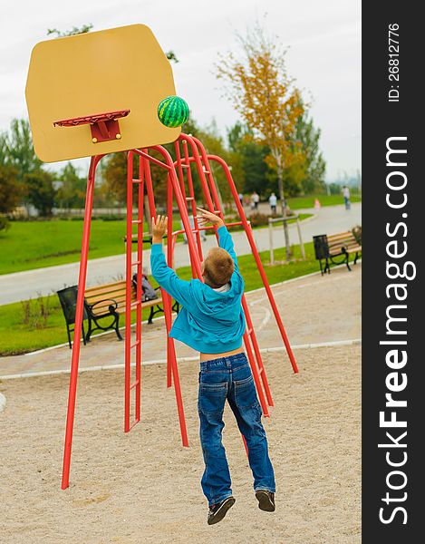 Young boy playing basketball at outdoors playground