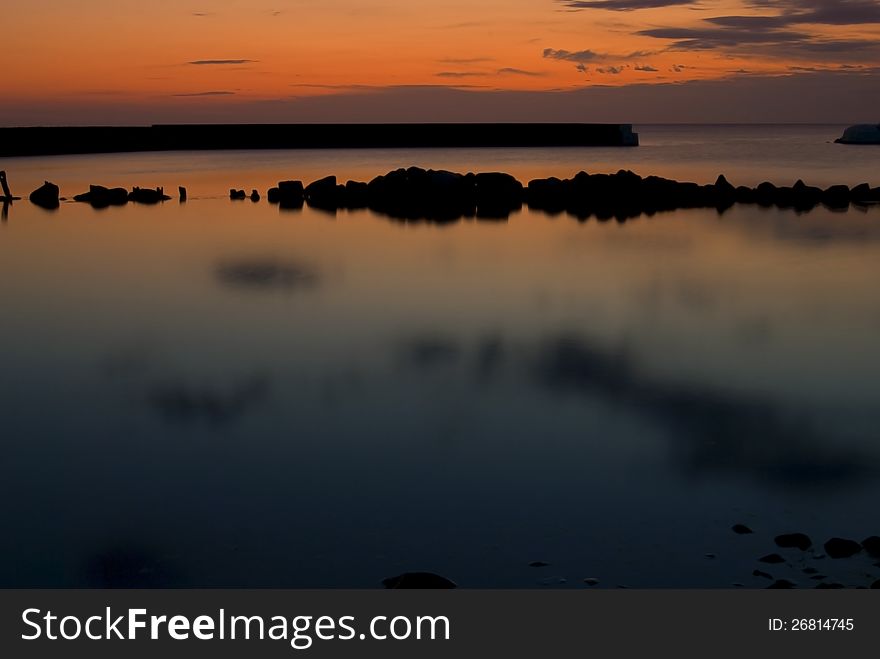 Beautiful sunrise In Kivik, colorful sky and calm water