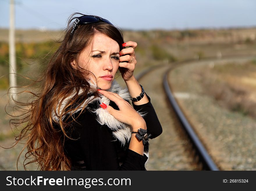 Pretty young woman standing by a railroad. Pretty young woman standing by a railroad