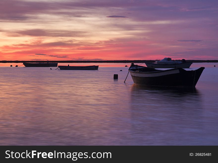 Beautiful view of sunrise with a beach and small fishing boats near Olhao, Portugal. Beautiful view of sunrise with a beach and small fishing boats near Olhao, Portugal.
