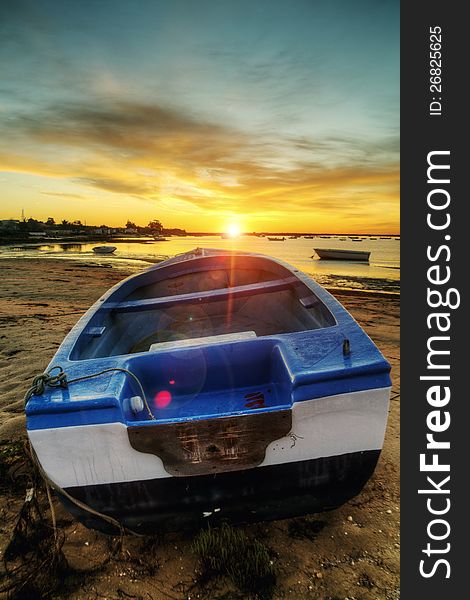 Beautiful view of sunrise with a beach and small fishing boats near Olhao, Portugal. Beautiful view of sunrise with a beach and small fishing boats near Olhao, Portugal.