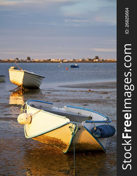 Beautiful view of sunrise with a beach and small fishing boats near Olhao, Portugal. Beautiful view of sunrise with a beach and small fishing boats near Olhao, Portugal.