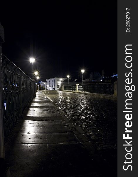 View of a eerie Tavira street in the night located in the Algarve, Portugal. View of a eerie Tavira street in the night located in the Algarve, Portugal.