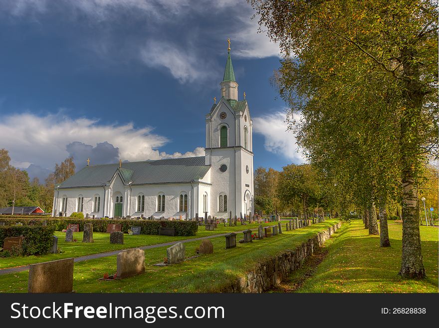 Church in Sweden with a single spire surrounded by grave stones