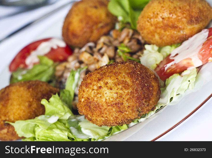 Close view of a tasty meal of chicken nuggets with salad.