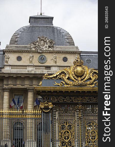 Partial view of a beautiful golden gate on a building in Paris, France.