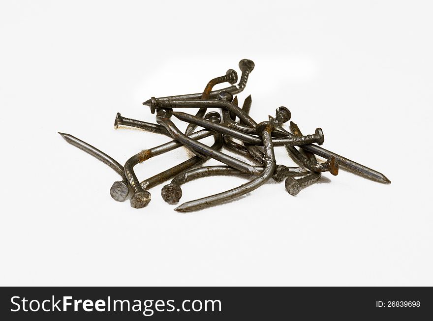 Rusty, bent nails on a white background. Rusty, bent nails on a white background.