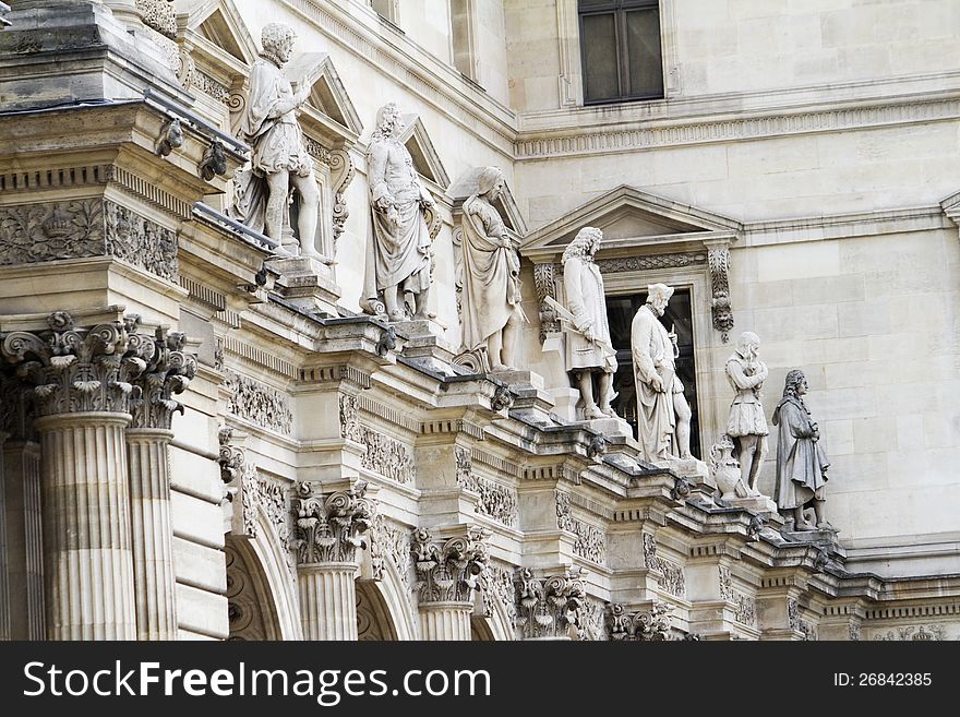 View of the beautiful statues located on the Museum of the Louvre in Paris, France