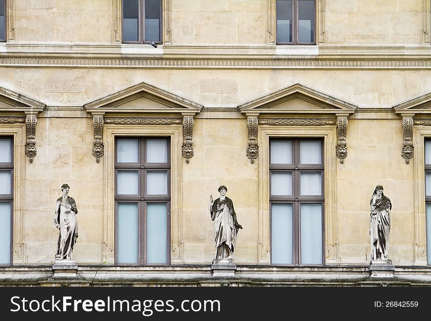 View of the beautiful statues located on the Museum of the Louvre in Paris, France