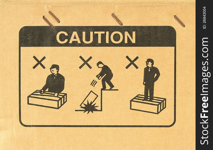 Caution symbol for workman on brown cardboard