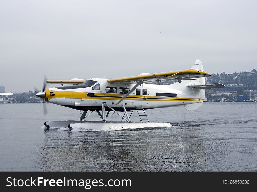 A float-plane was landing on a lake. A float-plane was landing on a lake