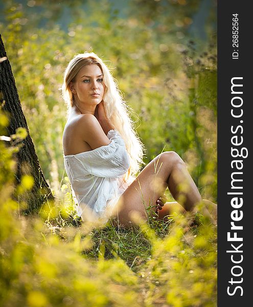 Young woman on field in white dress