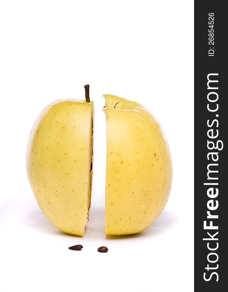 Close view of a tasty yellow apple sliced in half isolated on a white background. Close view of a tasty yellow apple sliced in half isolated on a white background.