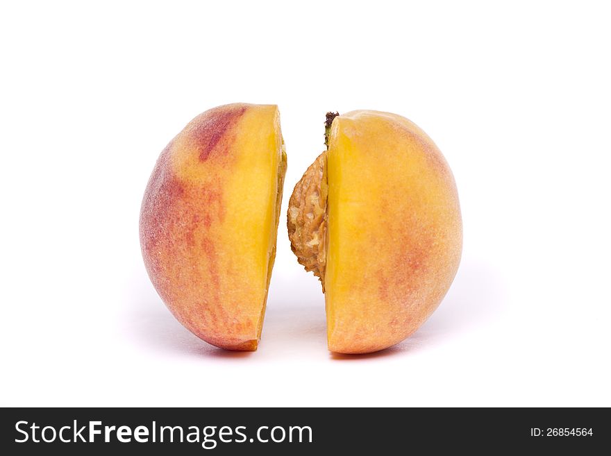 Close view of a tasty peach sliced in half isolated on a white background. Close view of a tasty peach sliced in half isolated on a white background.