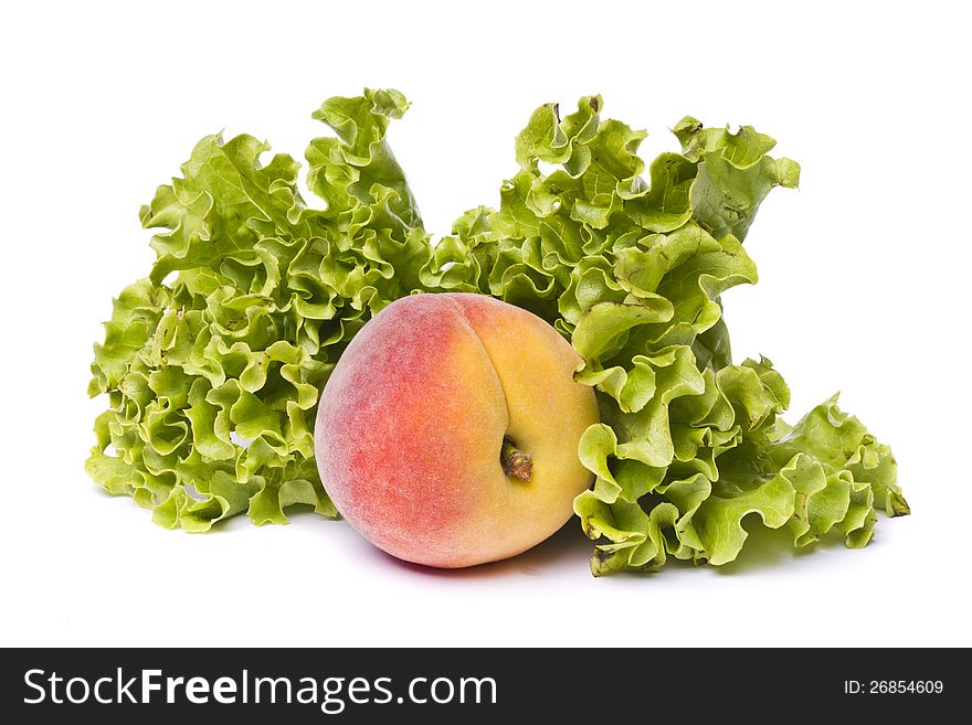 Close view of a tasty peach with lettuce isolated on a white background. Close view of a tasty peach with lettuce isolated on a white background.