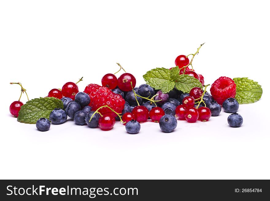 View of a bunch of tasty blueberries, red currant and raspberries isolated on a white background. View of a bunch of tasty blueberries, red currant and raspberries isolated on a white background.