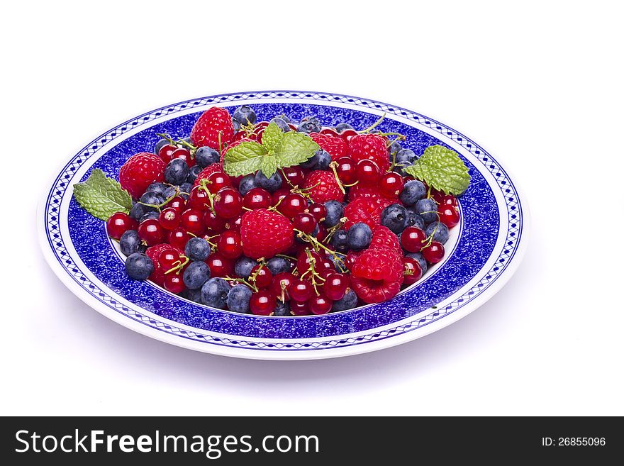 View of a bunch of tasty blueberries, red currant and raspberries isolated on a white background. View of a bunch of tasty blueberries, red currant and raspberries isolated on a white background.