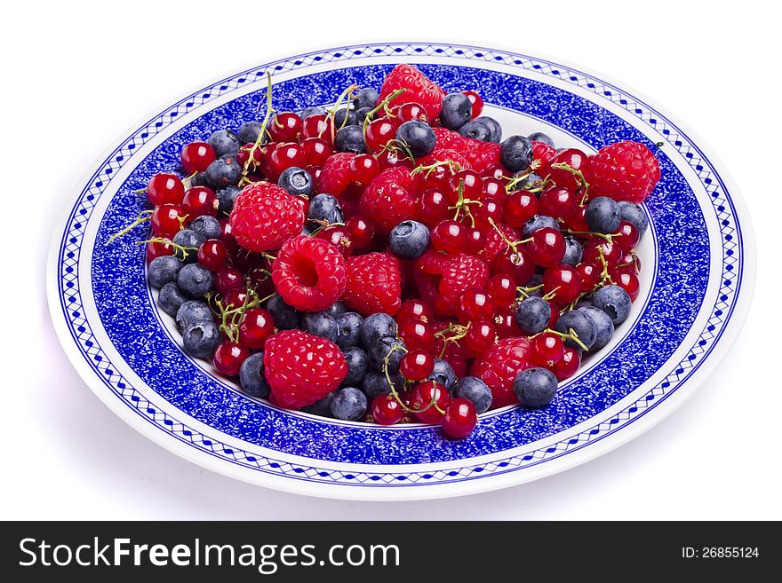 View of a bunch of tasty blueberries, red currant and raspberries isolated on a white background. View of a bunch of tasty blueberries, red currant and raspberries isolated on a white background.