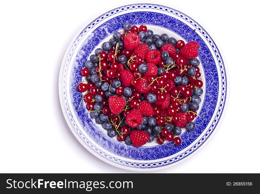 View of a bunch of tasty blueberries, red currant and raspberries isolated on a white background. View of a bunch of tasty blueberries, red currant and raspberries isolated on a white background.