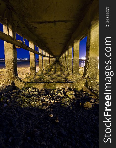 Infinite view under an old bridge at night in the beach. Infinite view under an old bridge at night in the beach.