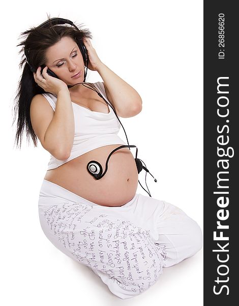 Music for two. The pregnant woman in earphones listens to music. Music for two. The pregnant woman in earphones listens to music