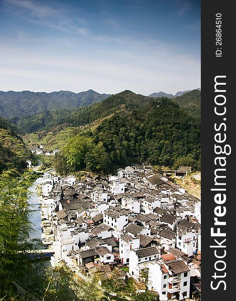 This photo captures the scene of the whole village which is built along a small river from the other side. This photo captures the scene of the whole village which is built along a small river from the other side.