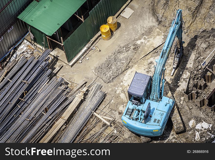 Construction in bird eye view with green backhoe .