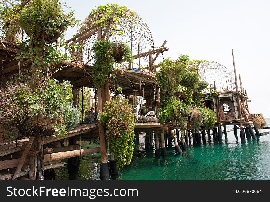 Tropical hanging garden over the ocean on a wooden pier in a sea resort