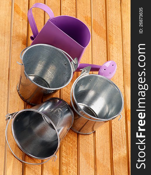 Garden Utensil with Tin Buckets and Watering Can on wooden background