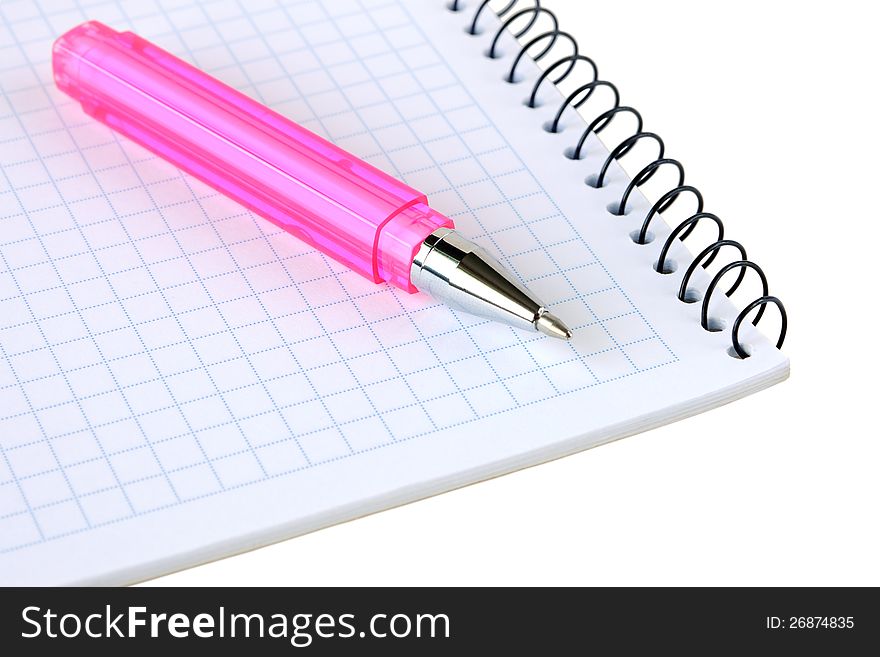 Pink pen lies on a notebook on a white background