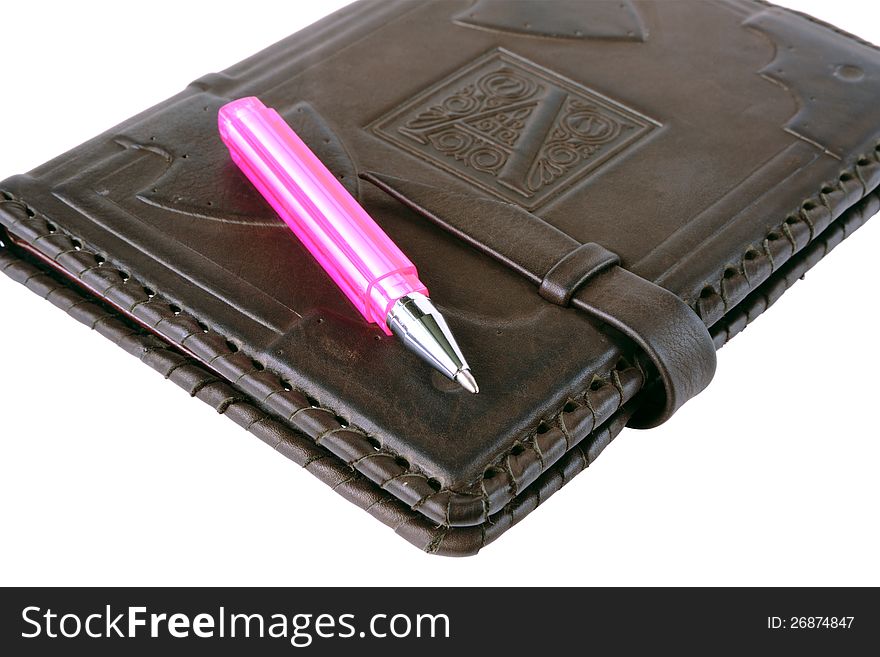 Pink pen lies on a notebook on a white background