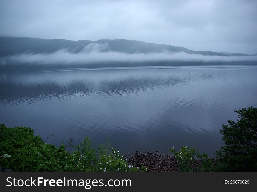 Scotland's Loch Ness with fog and rainy sky. Scotland's Loch Ness with fog and rainy sky.