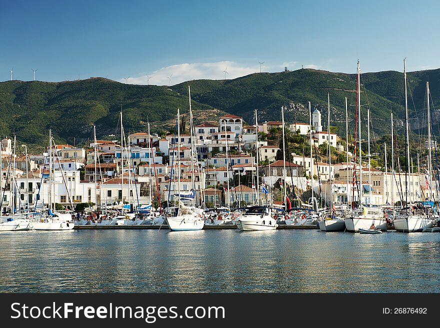 View of the Poros island, boats, village and hills behind from the sea, Greece. View of the Poros island, boats, village and hills behind from the sea, Greece