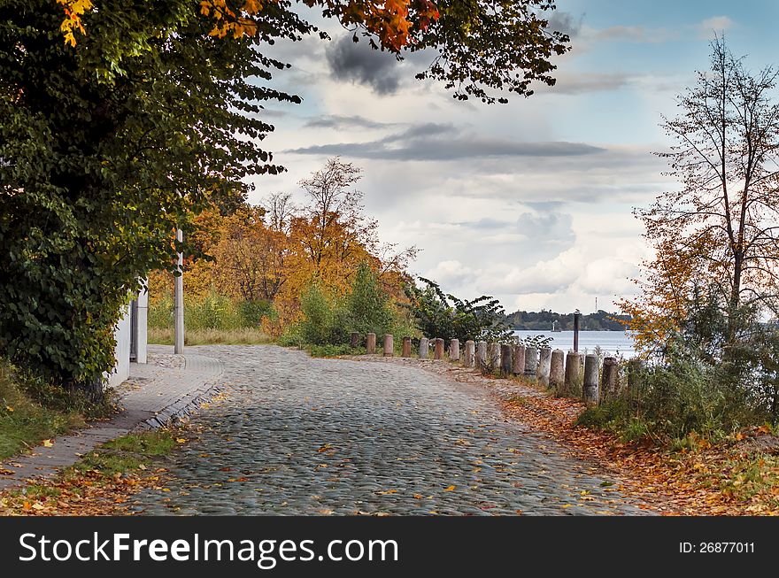 Old cobblestone road on the left bank of Daugave river in Riga city, Latvia, Europe. Old cobblestone road on the left bank of Daugave river in Riga city, Latvia, Europe