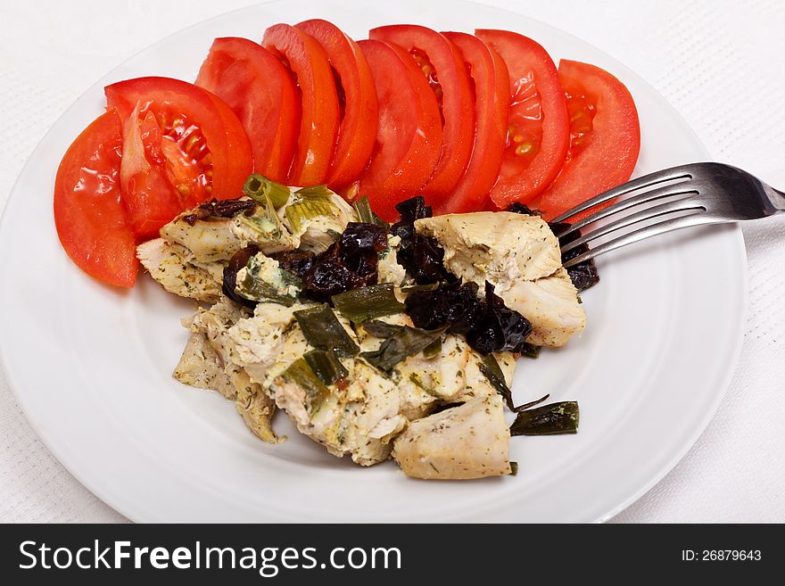 Dinner from chicken breast, prunes and tomatoes