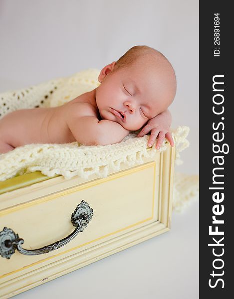 Newborn Baby Girl Sleeping in Yellow Drawer
