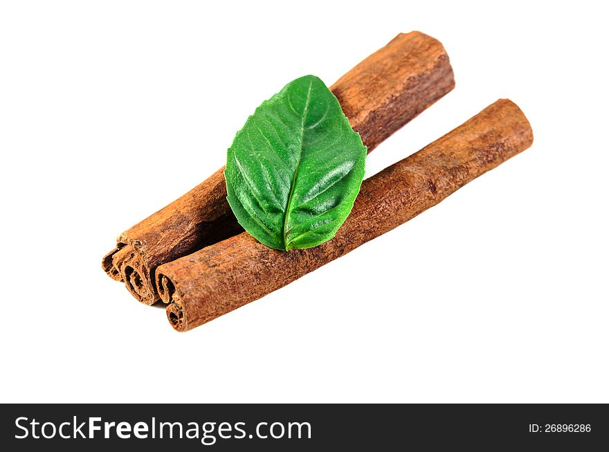 Cinnamon sticks and basil leaf isolated on a perfect white background