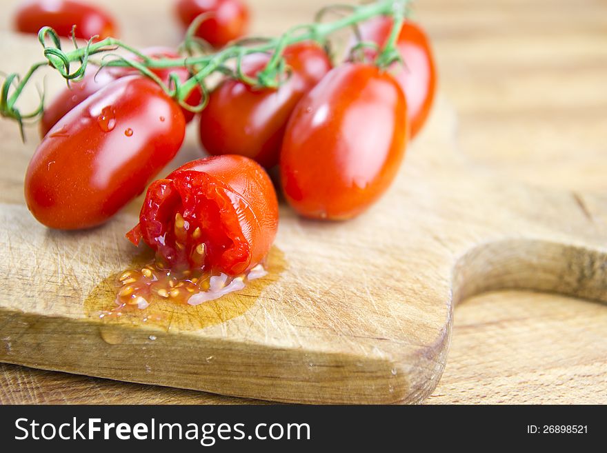 Fresh plum tomatoes over cutting board closeup