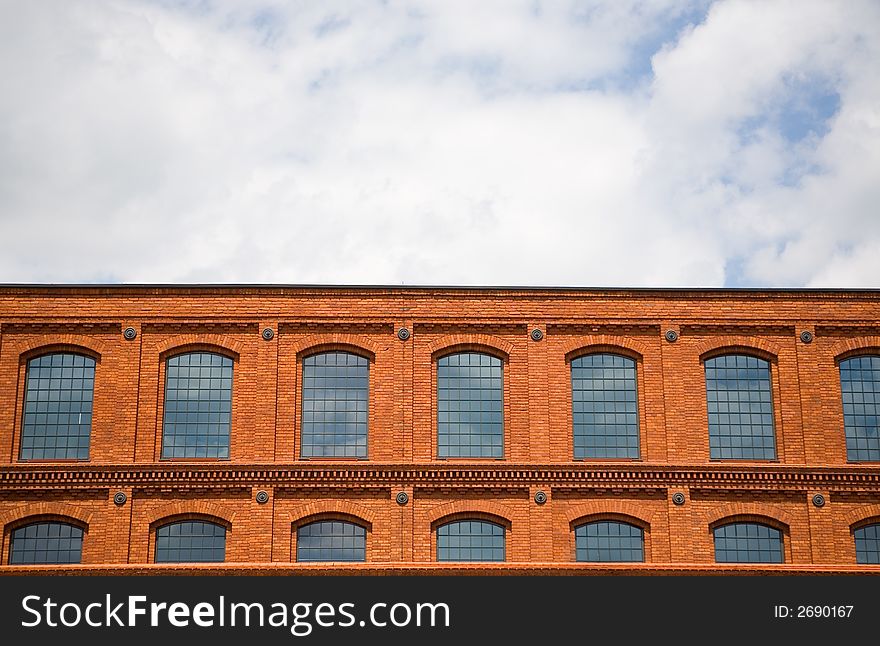 Brick wall background texture on cloudy sky