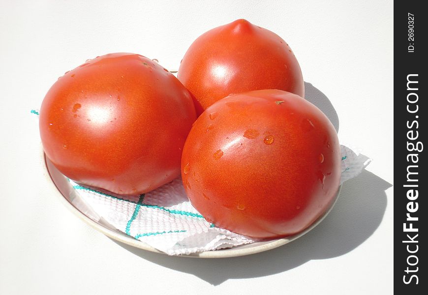 Ripe red juicy tomatoes on a dish