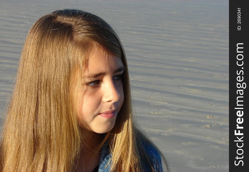 Young girl standing on the beach, looking into the distance