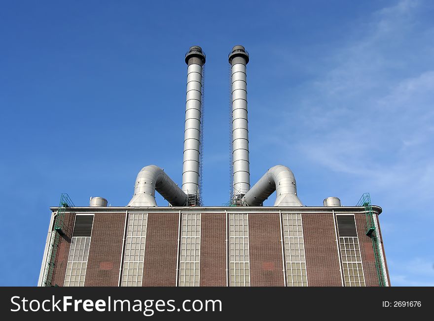 Large pipes on top of a factory making electricity from gas. Large pipes on top of a factory making electricity from gas